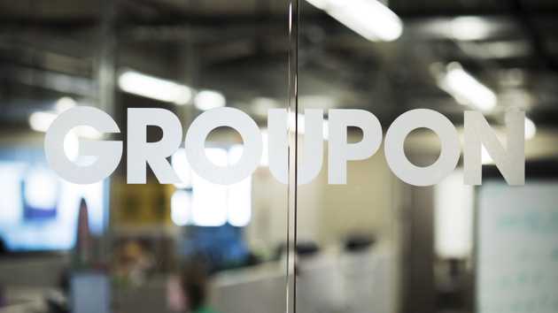 Glass doors with Groupon logo and blurred office in background